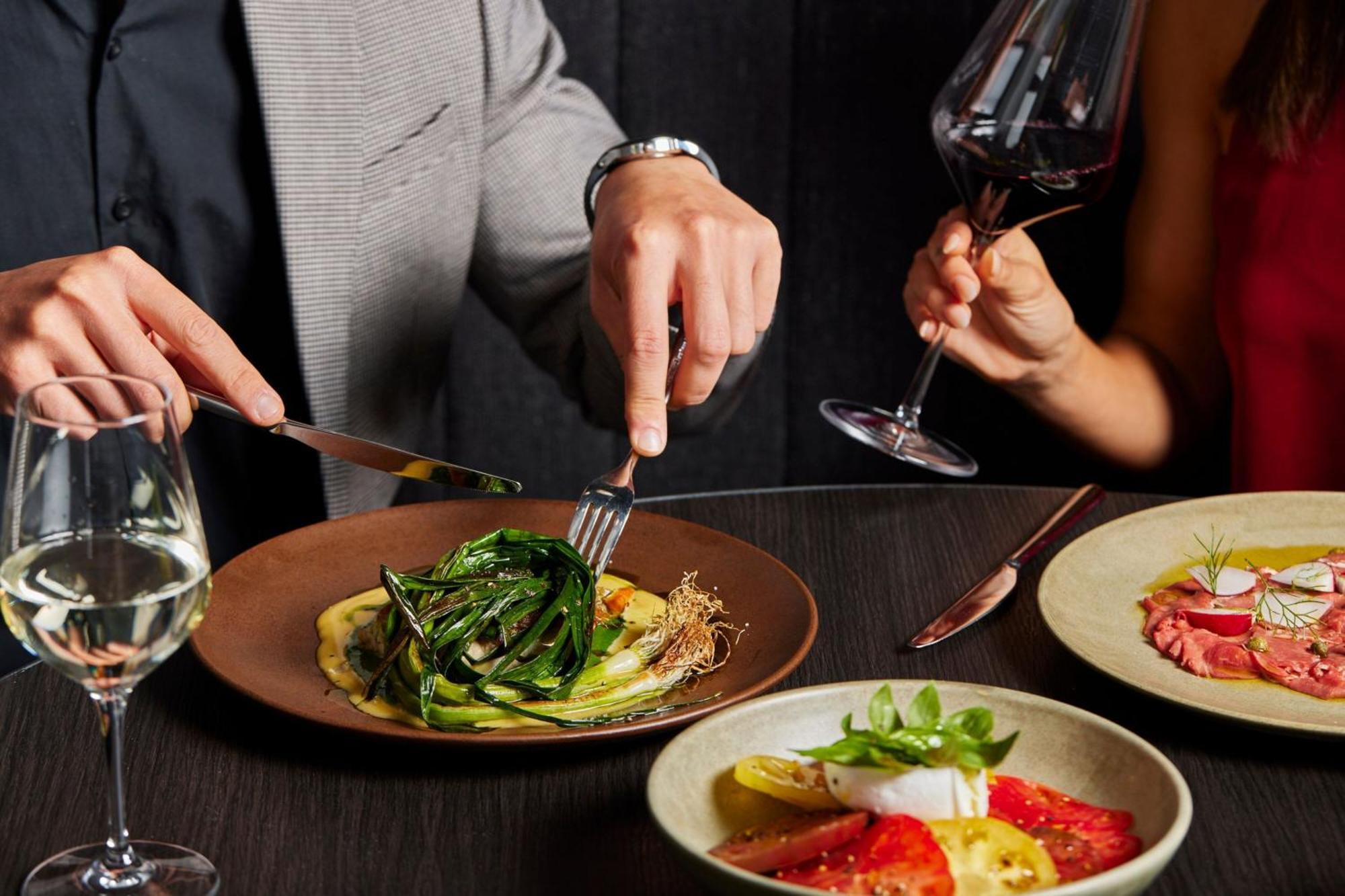 Melbourne Marriott Hotel Docklands Εξωτερικό φωτογραφία A man using a knife and fork to cut into a meal